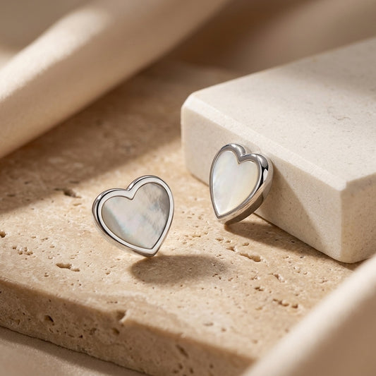 Heart-shaped earrings on a textured beige surface