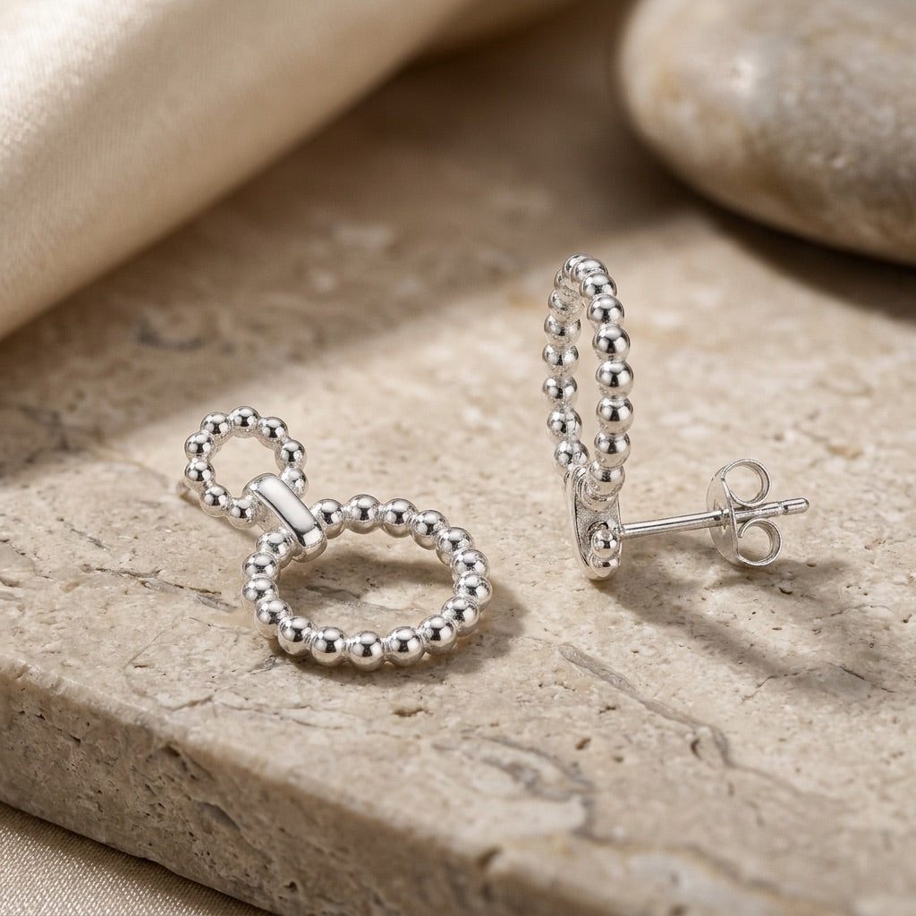 Silver Beaded Circle Link Drop Earrings on a stone surface