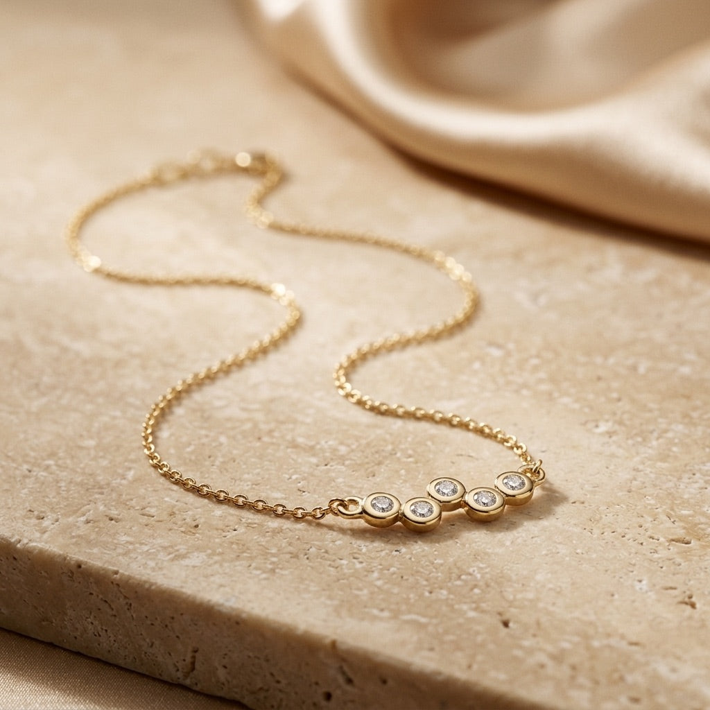 Golden Cubic Zirconia Gold Plate Scatter 18” Necklet on a beige stone surface