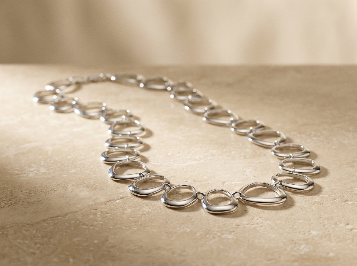 Silver necklace on a beige surface