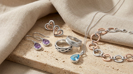 Assorted sterling silver jewellery including necklaces, bracelets and rings arranged in a minimal flat lay