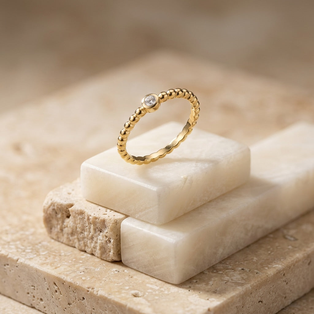 Gold ring with a diamond on a stone surface