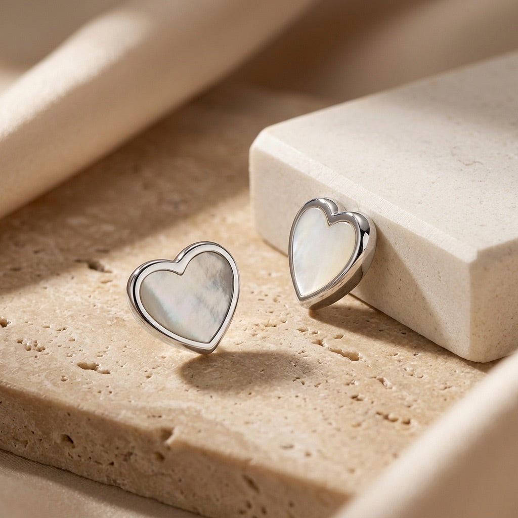 Heart-shaped earrings on a textured beige surface