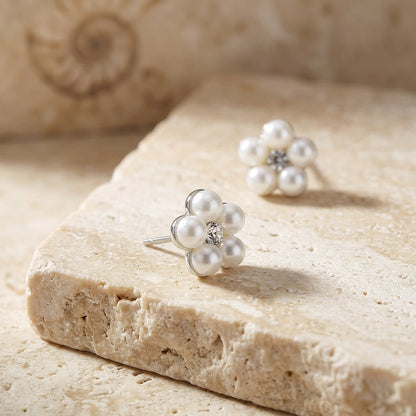 Pearl earrings on a textured stone surface