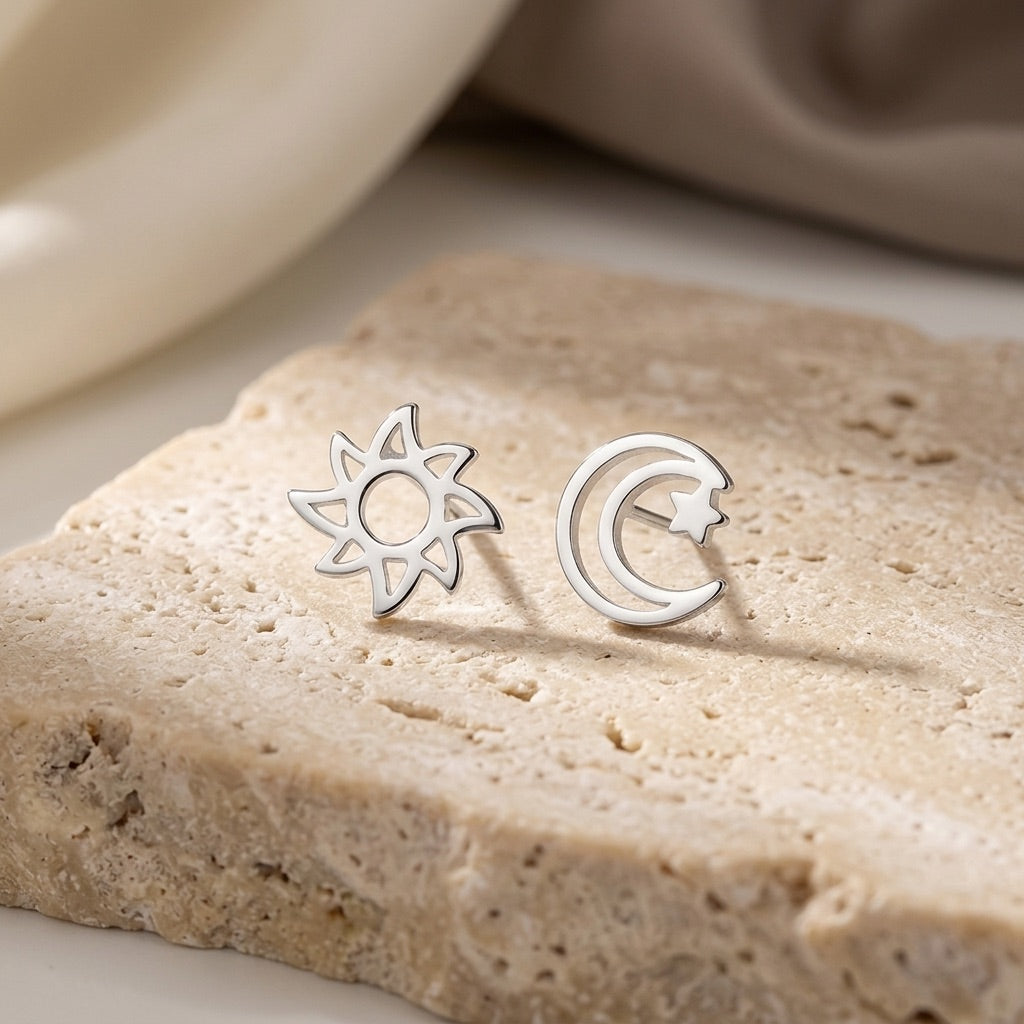 D4359SE - Sun, Moon & Star Silver Stud Earrings on a beige stone surface