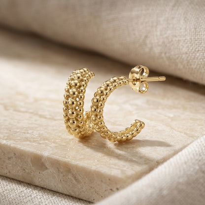 Gold Plate 13mm Triple Beaded Stud Hoop Earrings . on a beige stone surface
