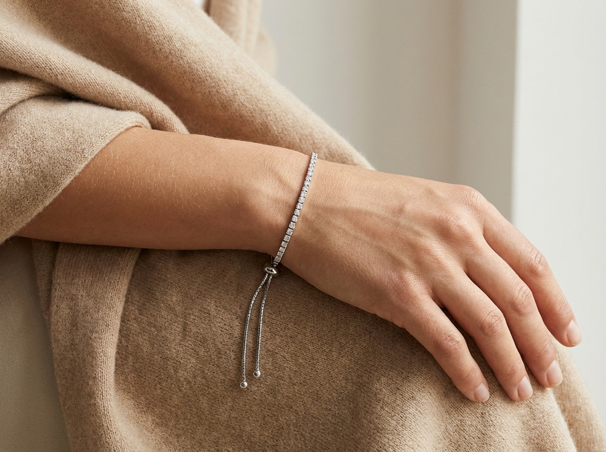 Close-up of a hand wearing a bracelet on a neutral background
