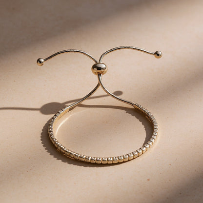 Gold bracelet with beaded design on a beige background