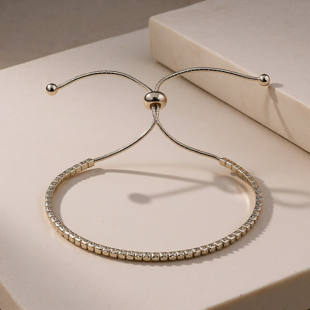Gold bracelet with clear stones on a beige surface