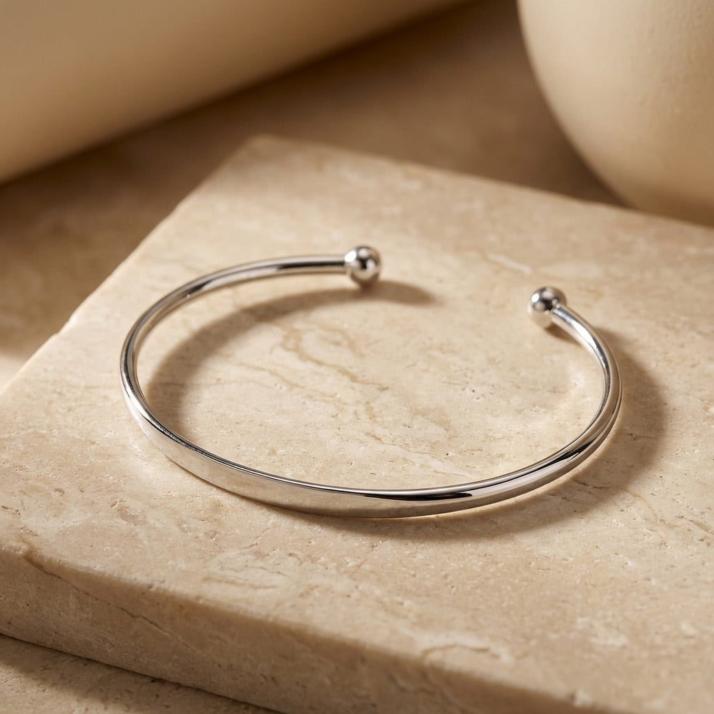Silver bracelet on a beige stone surface