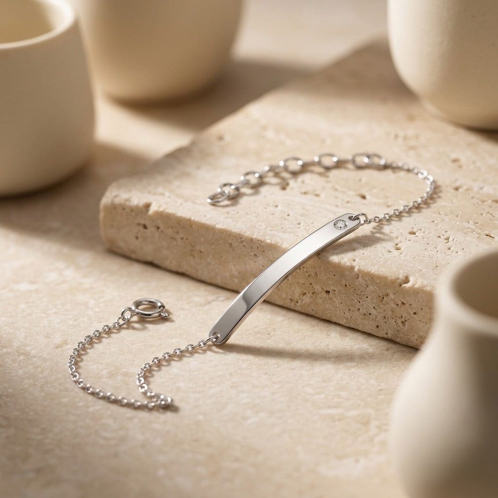 Classic ID Tag with Flush Set Cubic Zirconia 7” Bracelet on a stone surface with ceramic cups in the background