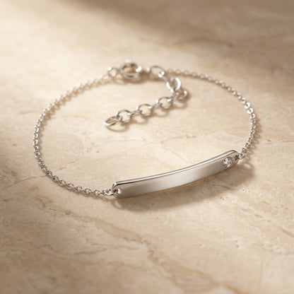 Classic ID Tag with Flush Set Cubic Zirconia 7” Bracelet on a beige marble surface