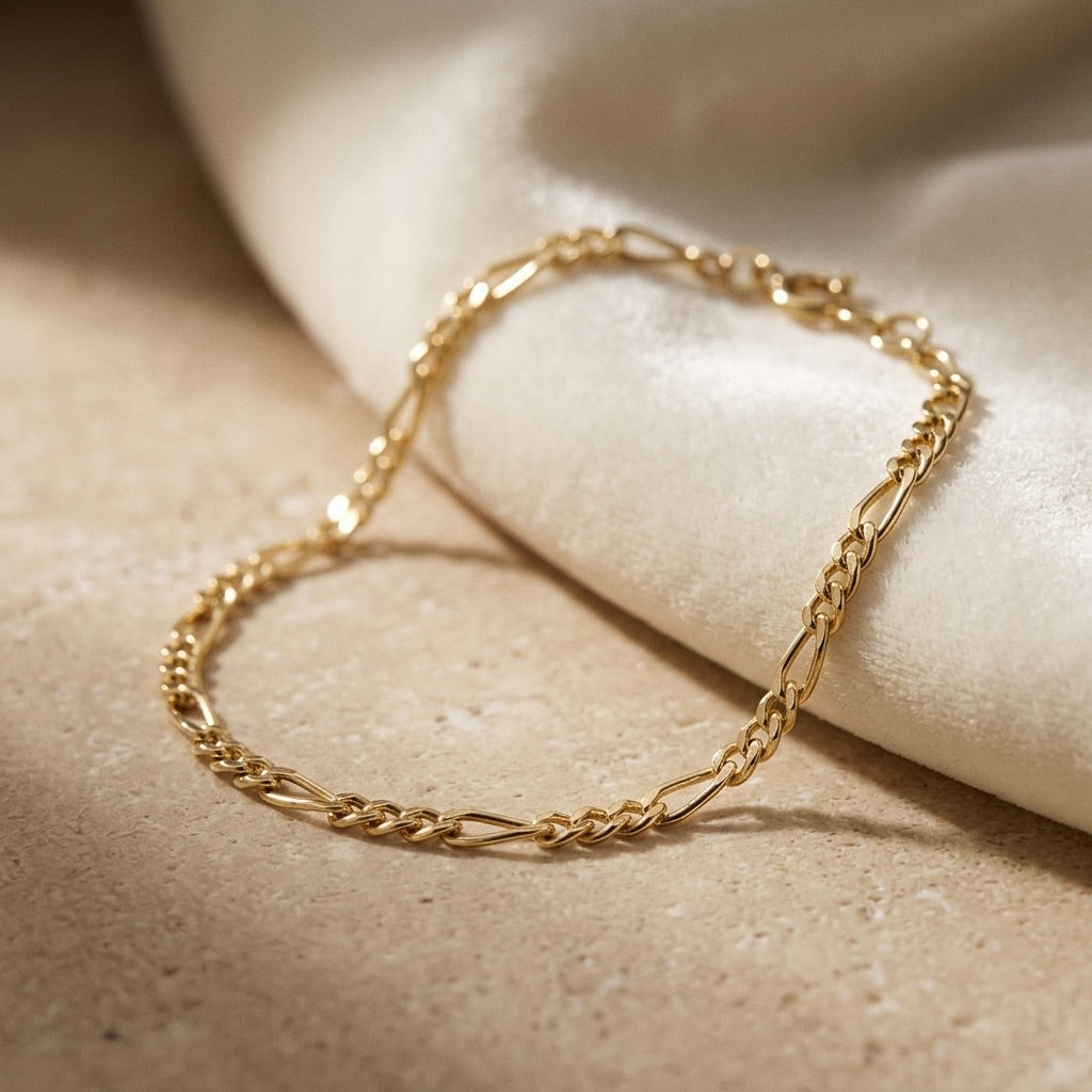 Golden Figaro Gold Plate Bracelet on a beige surface