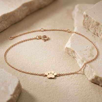 Gold Plate Paw Print 8” Bracelet on a stone surface