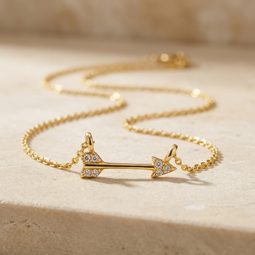 Golden Pavé Cubic Zirconia Arrow 18” Necklet on a beige surface