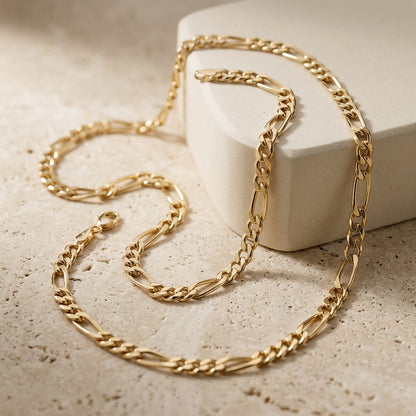 Gold chain necklace on a textured surface