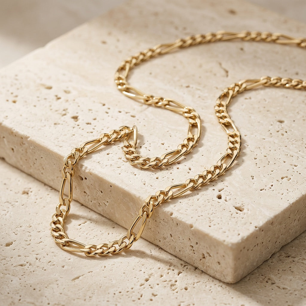Golden Gold Plate Figaro Chain 18” Necklace on a textured beige surface