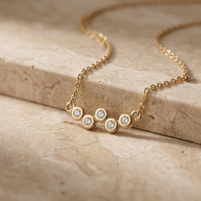 Golden Cubic Zirconia Gold Plate Scatter 18” Necklet on a beige stone surface