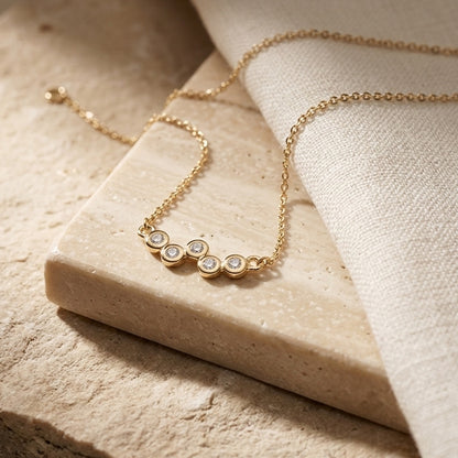 Golden Cubic Zirconia Gold Plate Scatter 18” Necklet on a beige stone surface