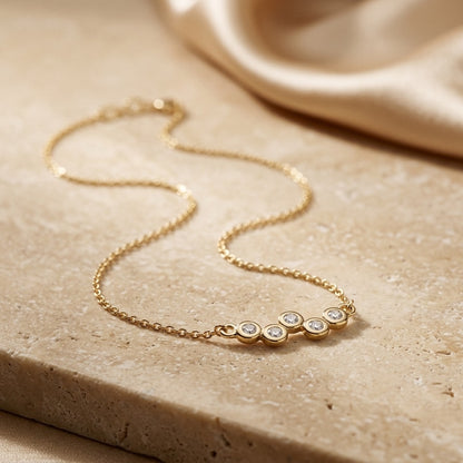 Golden Cubic Zirconia Gold Plate Scatter 18” Necklet on a beige stone surface