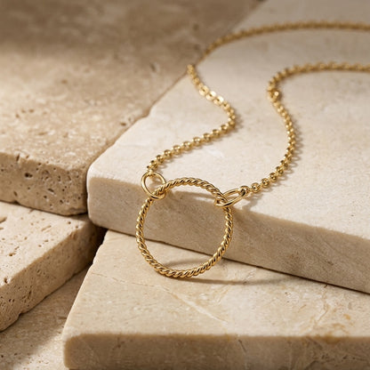 Golden Open Circle Rope Twist 18” Necklet on a beige stone surface