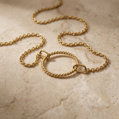 Golden Open Circle Rope Twist 18” Necklet on a textured beige surface