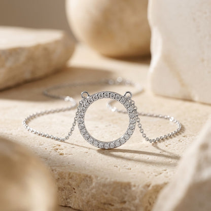 Silver necklace with circular pendant on a beige surface