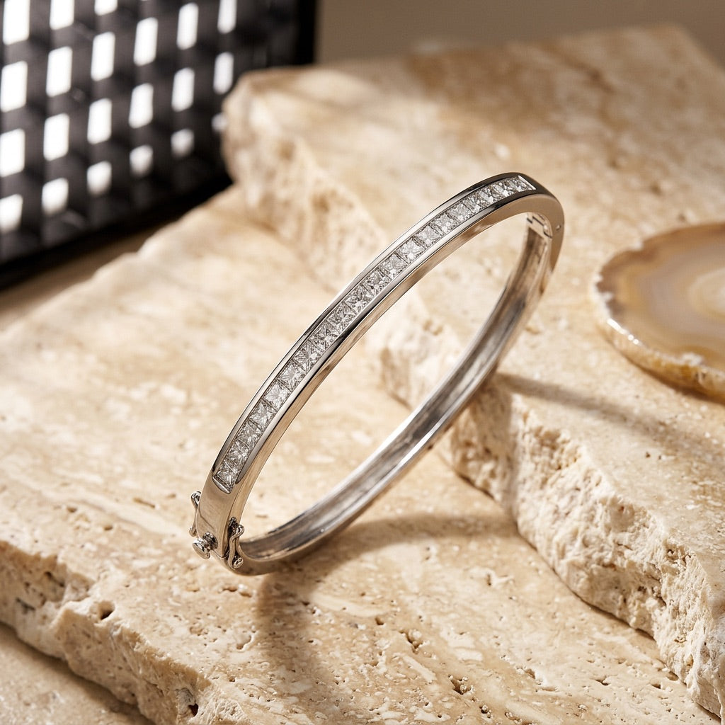 Silver bracelet with small diamonds on a textured stone surface