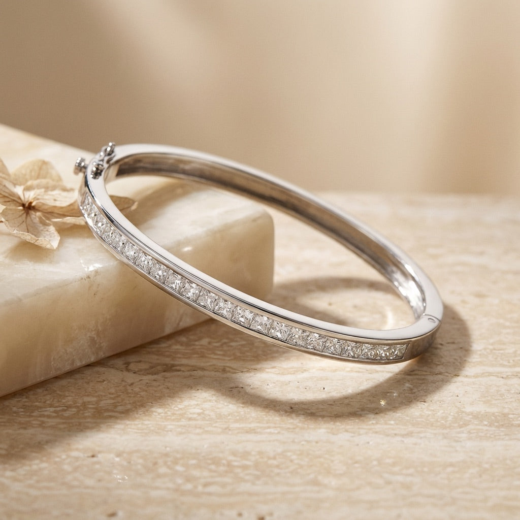 Silver bracelet with small stones on a beige stone surface
