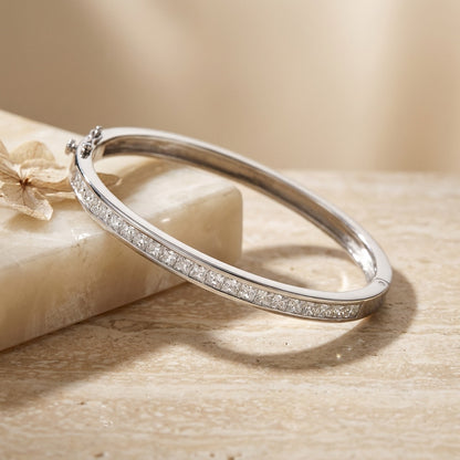Silver bracelet with small stones on a beige stone surface