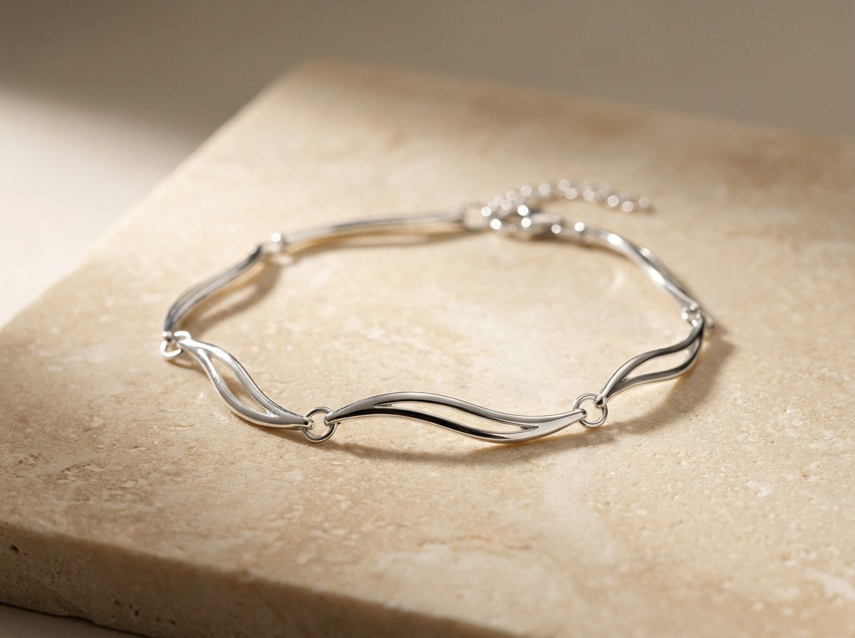 Silver bracelet on a beige stone surface