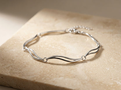 Silver bracelet on a beige stone surface