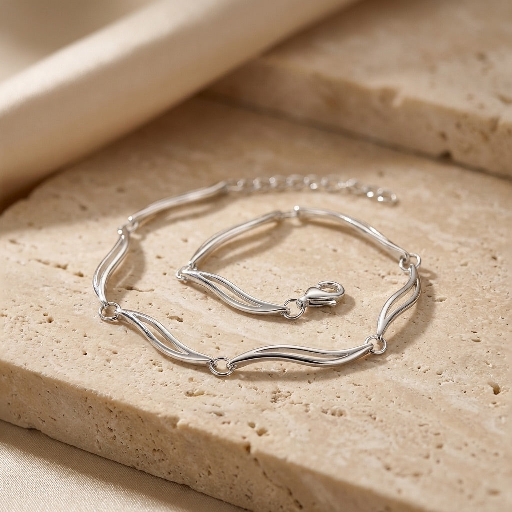 Silver linked leaved bracelet on a textured beige surface | Alpha Bijoux