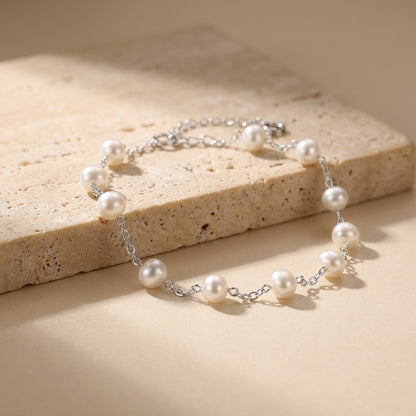 Pearl bracelet on a beige stone surface