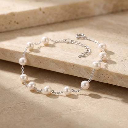 Pearl bracelet on a beige stone surface