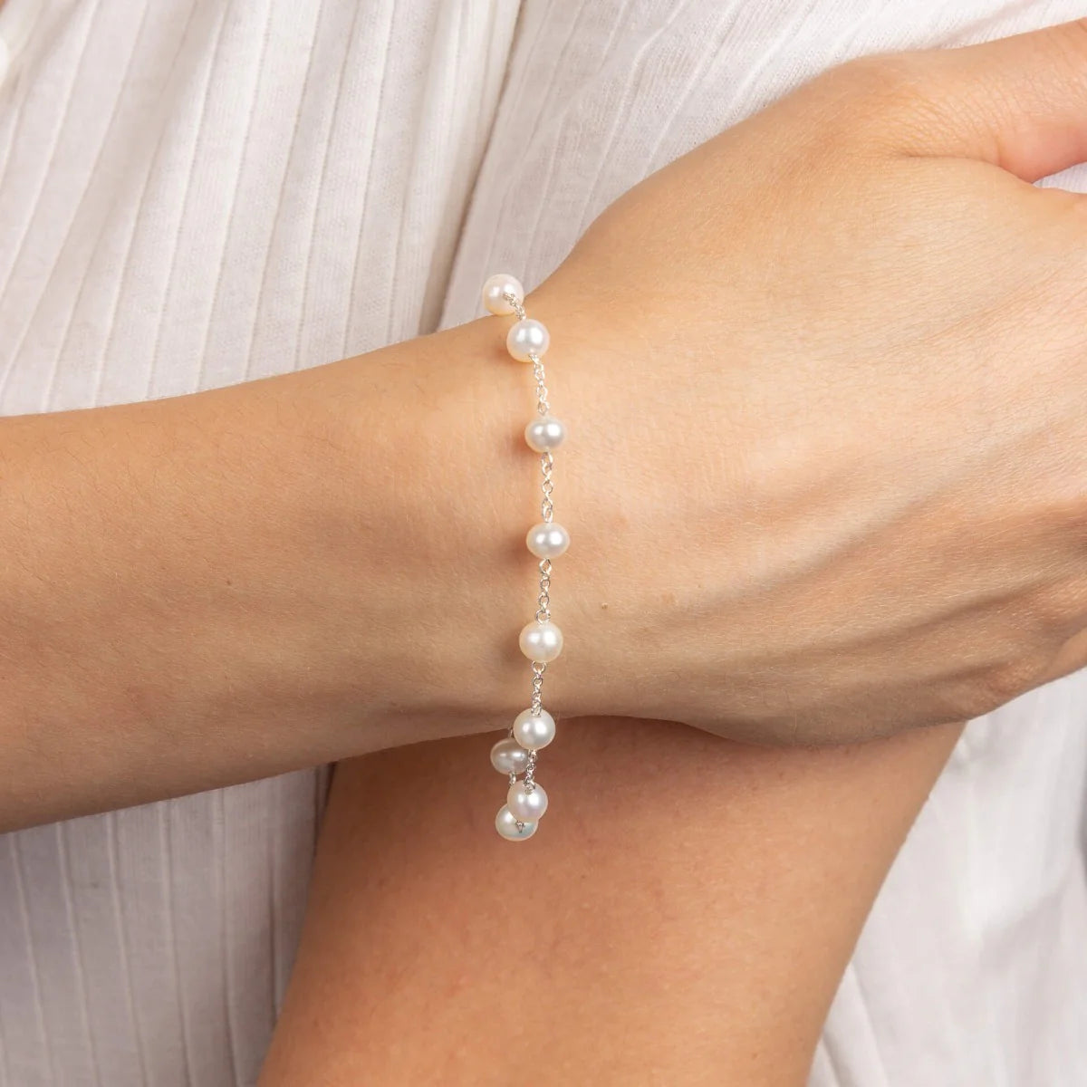 Pearl bracelet on a person's wrist with a light background