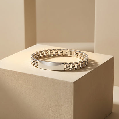 Gold chain bracelet on a beige cube with a neutral background
