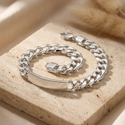 Silver chain bracelet on a beige stone surface