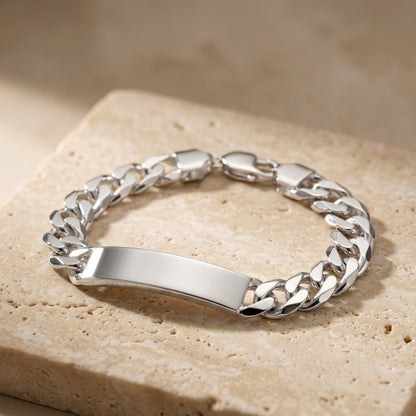Silver chain bracelet on a beige stone surface