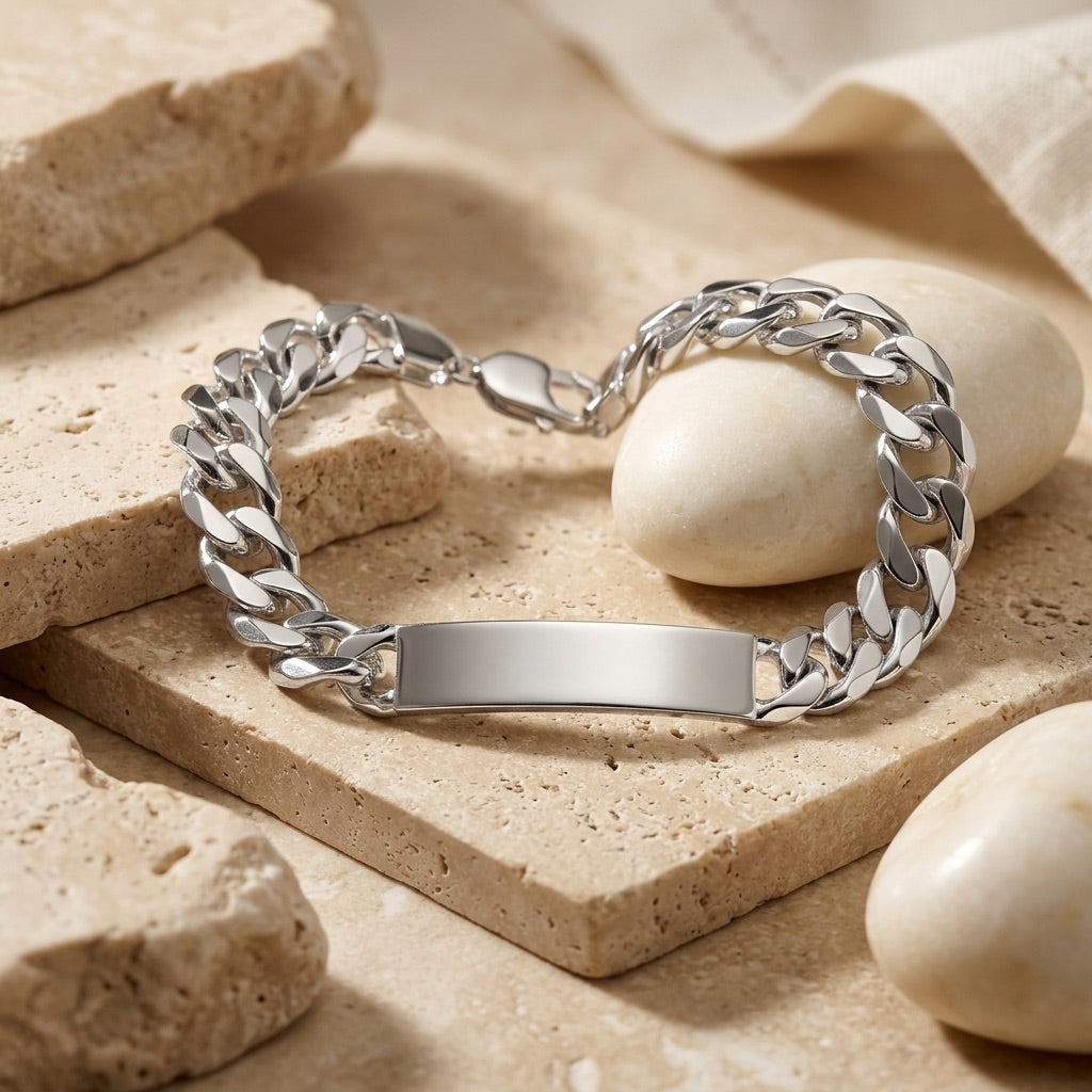 Silver chain bracelet with a nameplate on a beige stone surface
