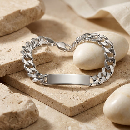 Silver chain bracelet with a nameplate on a beige stone surface