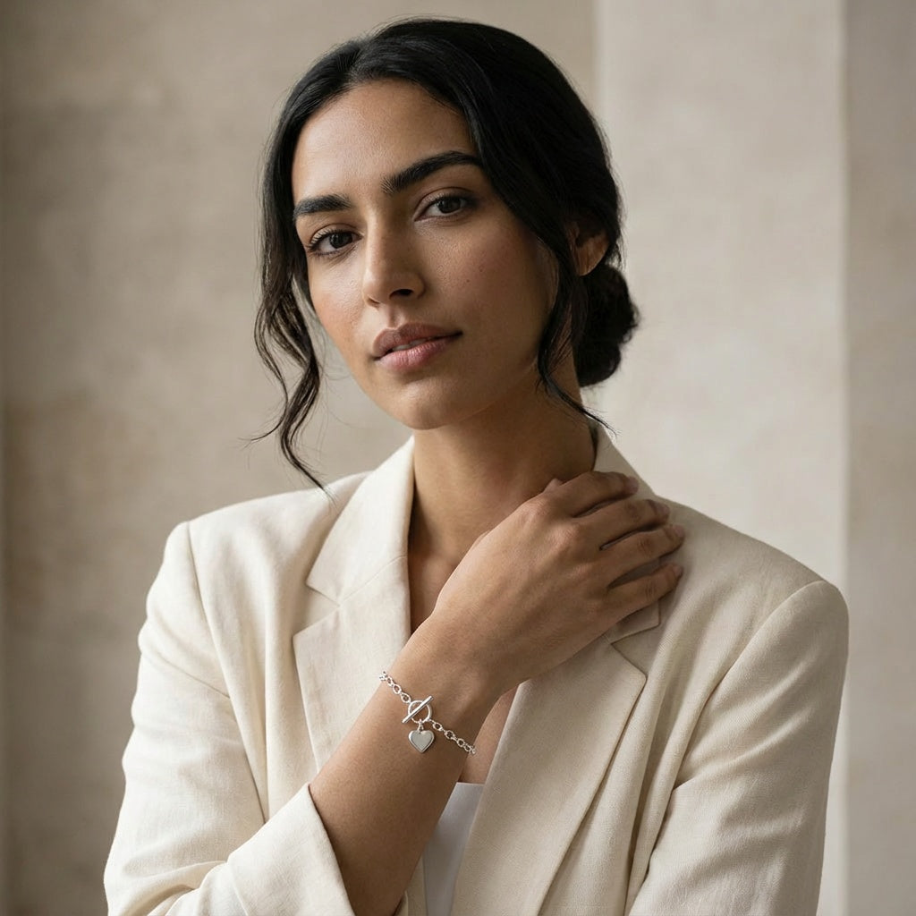 Woman wearing a beige blazer and Ball Chain Bracelet with Heart Tag bracelet against a neutral background