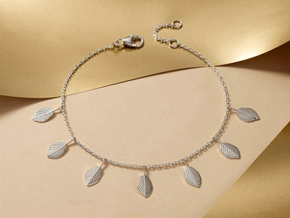 Silver necklace with leaf pendants on a beige background