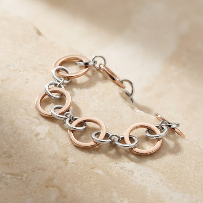 Bracelet with rose gold and silver links on a beige stone background
