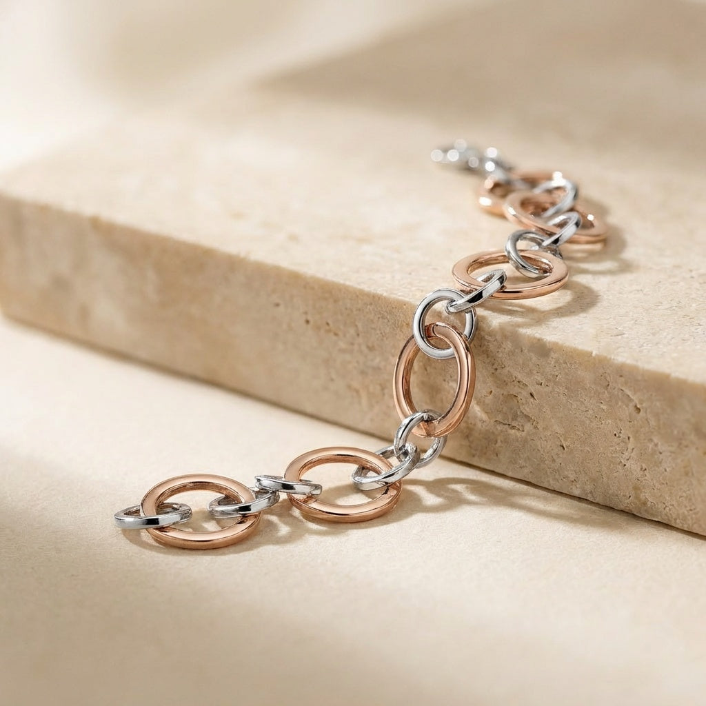 Two-tone chain bracelet on a beige stone surface