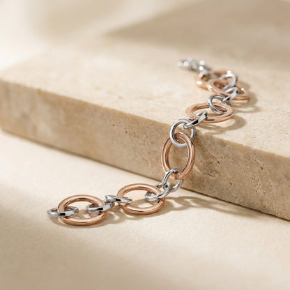 Two-tone chain bracelet on a beige stone surface