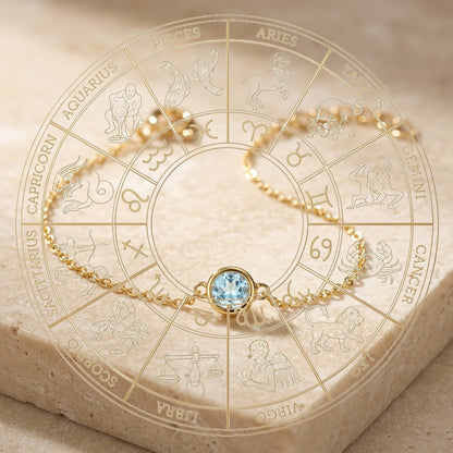 Gold bracelet with a blue gemstone on a zodiac wheel background
