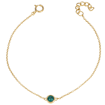 Gold bracelet with a green gemstone on a white background