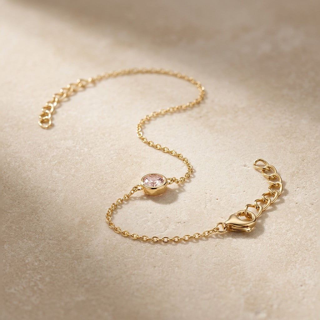 Gold bracelet with a heart clasp on a beige background