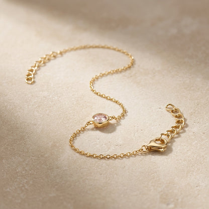 Gold bracelet with a heart clasp on a beige background